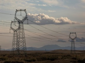 Transmission towers supporting ultra-high voltage power lines and other high voltage power lines near a solar farm operated by Yellow River Power in Gonghe County, Qinghai province, China, on Sept. 27, 2021.