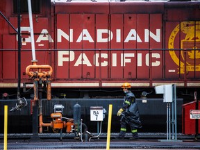 A CP Rail employee walks past locomotives in the Alyth yards in Calgary on Sept. 15, 2021.