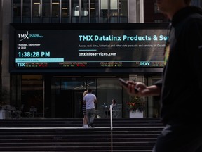 Pedestrians pass in front of the Toronto Stock Exchange in the financial district of Toronto on Sept 16, 2021.
