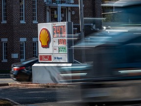 A truck drives past a price board at a Shell gas station in Alexandria, Virginia, on Nov. 23, 2021.