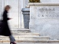 A woman walks past the Bank of Canada building in Ottawa.