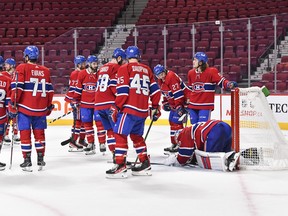 Members of the Montreal Canadiens huddle around goaltender Cayden Primeau #30 as he lays on the ice with discomfort after making a save to help win the game in a shootout against the Philadelphia Flyers at Centre Bell on Dec. 16, 2021 in Montreal.
