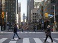 Morning commuters cross Yonge Street at Bay Street in the financial district of Toronto.