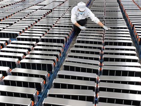 A worker with car batteries at a factory for Xinwangda Electric Vehicle Battery Co. Ltd, which makes lithium batteries for electric cars and other uses, in Nanjing in China's eastern Jiangsu province.