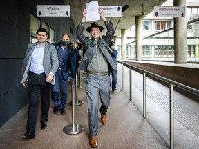 Lawyer Roger Cox, left, and Director of Dutch environment organisation 'Milieudefensie' Donald Pols react as they walk outside a court in The Hague on May 26, 2021, after the district court ruled that Anglo-Dutch multi-national Shell must reduce its emissions by 45 per cent by 2030.