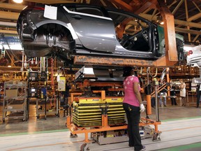 An autoworker installs a battery pack in a Chevrolet Bolt at a General Motors facility in Detroit, Michigan.