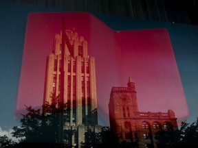 Commercial and residential buildings are reflected in the window of the National Bank of Canada headquarters in Montreal.