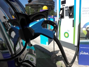 An electric powered taxi is seen being charged at a BP Pulse electric vehicle charging point in London, Britain.