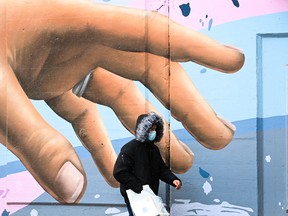 A man wearing a protective mask walks in Toronto.