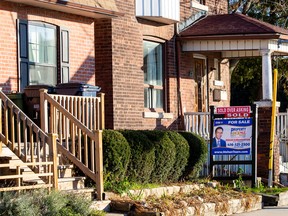 A for sale sign is displayed outside a home in Toronto.