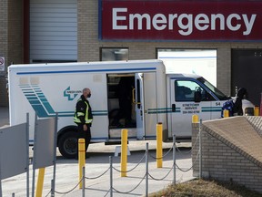 A health care worker helps unload a stretcher service vehicle at St. Boniface Hospital in Winnipeg, Manitoba.