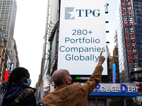 A screen announces the listing of private-equity firm TPG, during the IPO at the Nasdaq Market site in Times Square in New York City, Jan. 13, 2022.