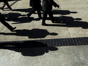 Businessmen cast their shadows as they walk in Toronto's financial district.