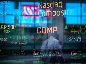 Monitors displaying stock market information are seen through the window of the Nasdaq MarketSite in the Times Square neighbourhood of New York.