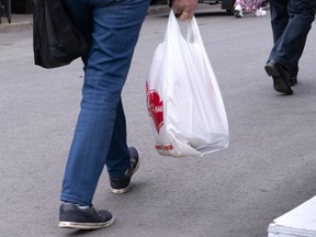 A woman carries a plastic bag at a market in Montreal.