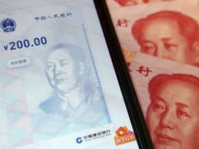 China's official app for digital yuan on a mobile phone next to 100-yuan banknotes.