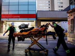 Ambulance crew members deliver a patient at Mount Sinai Hospital in Toronto as officials warned of a "tsunami" of new coronavirus disease (COVID-19) cases in the days and weeks ahead due to the Omicron variant.
