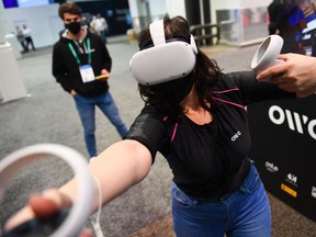 An attendee demonstrates the Owo vest, which allows users to feel physical sensations during metaverse experiences such as virtual reality games, including wind, gunfire or punching, at the Consumer Electronics Show (CES) on January 5, 2022 in Las Vegas, Nevada.