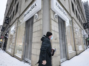 A pedestrian walks past a closed Pandora jewelry store in Montreal, Quebec, Canada, on Sunday, Jan. 9, 2022. Quebec Premier Francois Legault announced on Tuesday that the province's stores would be closed on three Sundays, with some exceptions, to curb coronavirus hospitalizations.