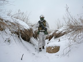 A service member of the Ukrainian armed forces walks at combat positions near the line of separation from Russian-backed rebels outside the town of Avdiivka in Donetsk Region, Ukraine January 25, 2022.