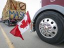 Die kanadische Flagge spiegelt sich in einer Radnabe, als ein LKW-Konvoi die Autobahn des stark befahrenen US-Grenzübergangs in Coutts, Alta, blockiert.