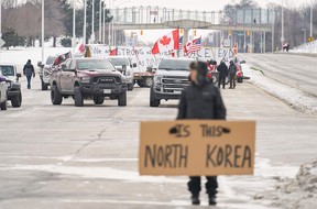 Demonstranten gegen das Impfmandat blockieren am Dienstag die Fahrbahn, die den Grenzübergang Ambassador Bridge in Windsor, Ontario, Kanada, verlässt.