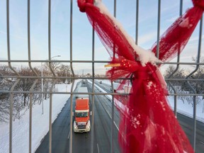 A truck drives under a pedestrian bridge on the route from the Ambassador Bridge border crossing in Windsor, Ontario on Monday. Canada's most travelled land crossing with the United States is open again after being blocked for almost a week by protests. Economics and industry leaders are assessing the damage.