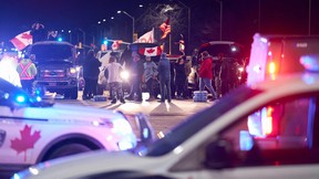 Anti-vaccine mandate protestors block an intersection near the Ambassador Bridge border crossing, in Windsor on Thursday demanding to be let in to the main protest site at the border.