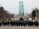 Die Polizei versammelt sich, um Demonstranten gegen COVID-19-Impfstoffmandate zu beseitigen, die am Sonntag den Eingang zur Ambassador Bridge in Windsor, Ontario, blockiert haben.