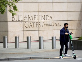 A person passes by on a scooter in front of the Bill & Melinda Gates Foundation in Seattle, Washington.