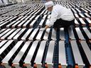 A worker with car batteries at a factory for Xinwangda Electric Vehicle Battery Co. Ltd, which makes lithium batteries for electric cars and other uses, in Nanjing in China's eastern Jiangsu province. 