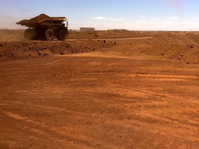 An autonomous vehicle drives along a road as it collects iron ore at Australia's Fortescue Metals Group mine in the Pilbara region.