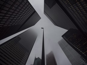 The Canadian flag blows in the wind in the heart of the financial district in Toronto.