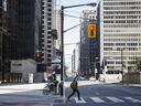 A pedestrian crosses Bay Street in the financial district of Toronto.
