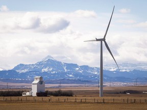 A wind turbine overshadows a grain elevator near Pincher Creek, Alta.