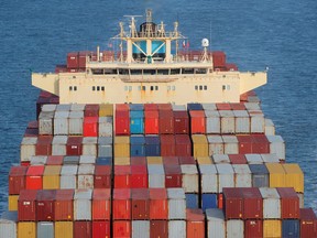 Container werden auf dem Deck eines Frachtschiffs gestapelt, während es im Hafen von New York unterwegs ist.