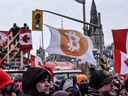 A protester holds a Bitcoin flag during a demonstration near Parliament Hill in Ottawa on Feb. 12, 2022. 