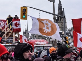 A protester holds a Bitcoin flag during a demonstration near Parliament Hill in Ottawa on Feb. 12, 2022.