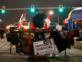 A DJ plays as protestors and supporters attend a blockade at the foot of the Ambassador Bridge, sealing off the flow of commercial traffic over the bridge into Canada from Detroit on Thursday in Windsor. As a convoy of truckers and supporters continues to occupy Ottawa's downtown, blockades and convoys have popped up around the country in support of the protest against Canada's COVID-19 vaccine mandate for cross-border truckers.