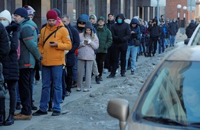 As pessoas fazem fila para usar um caixa eletrônico em São Petersburgo no domingo, quando o Ocidente suspendeu as sanções financeiras contra a Rússia.