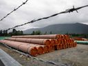 Pieces of the Trans Mountain Pipeline project sit in a storage area outside Hope, British Columbia this past June.  Erratic weather and the pandemic have delayed construction.