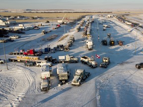 A truck convoy of anti-COVID-19 vaccine mandate demonstrators continue to block the highway at the busy U.S. border crossing in Coutts, Alta., Wednesday, Feb. 2, 2022.