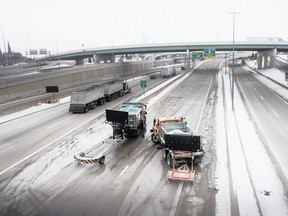 Michigan Department of Transportation (MDOT) salt trucks block off the access ramps to Ambassador Bridge for trucks traveling into Canada in Detroit, Michigan, U.S., on Tuesday, Feb. 8, 2022. Hundreds of trucks and truck drivers attempting to cross Ambassador Bridge from Detroit, Michigan to Windsor, Canada are stuck on the U.S. side after the bridge was closed by Canadian protesters over vaccine mandates.