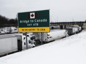 Trucks wait on Interstate 75 for the re-opening of Ambassador Bridge in Detroit, Michigan, U.S., on Tuesday, Feb. 8, 2022.