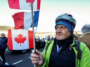 A French activist holds a Canadian flag before the start of their 'Convoi de la liberte, on Wednesday in Nice, France.