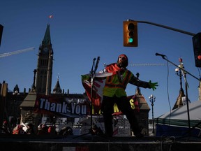 A man dances on a stage during a protest in Ottawa, on Monday.
