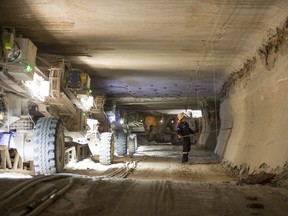 A Nutrien employee knocks away loose potash in a mine shaft in Saskatchewan.