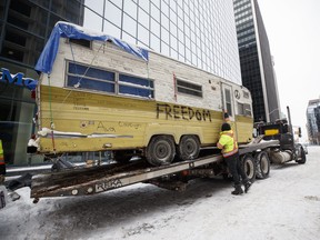 A man secures camper before it gets hauled away in Ottawa, on Sunday, Feb. 20, 2022.