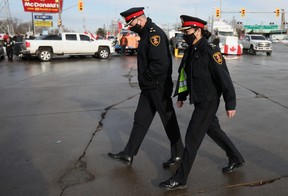 Windsor Chief of Police Pam Mizuno and Deputy Chief Frank Providenti walk beside the protest blocking the route leading from the Ambassador Bridge on Wednesday.