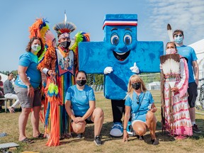 Alberta Blue Cross team members (including Big Blue) and members of the local Indigenous community supporting the 2021 World Triathlon Championship Finals that were held in Edmonton.   VIVID RIBBON INC. PHOTOGRAPH